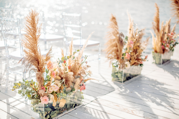 Wedding by the sea. Beach wedding venue. Wooden stage with floral decorations