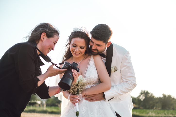 Wedding photographer with a professional camera shooting bride and groom